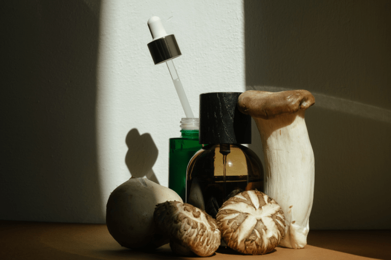beauty products surrounded by mushrooms as advanced biopolymers